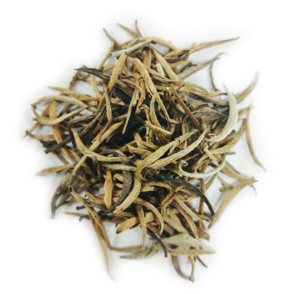 Close-up of dried golden buds and whole white tea leaves, showcasing the premium Ceylon Golden Tips white tea from Sri Lanka