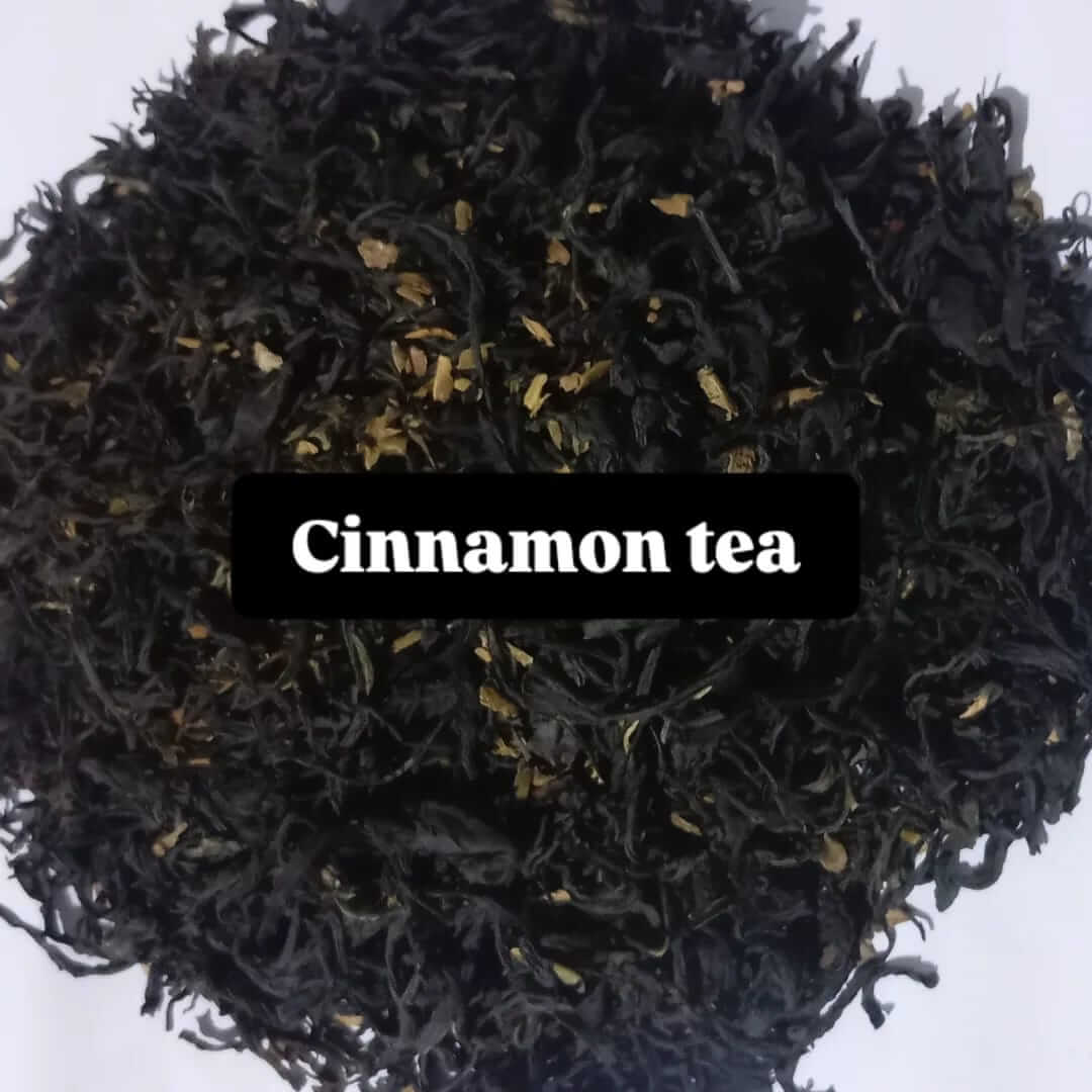 Close-up of dried black cinnamon tea leaves with small golden cinnamon pieces, labeled 'Cinnamon tea' for rich aromatic flavor